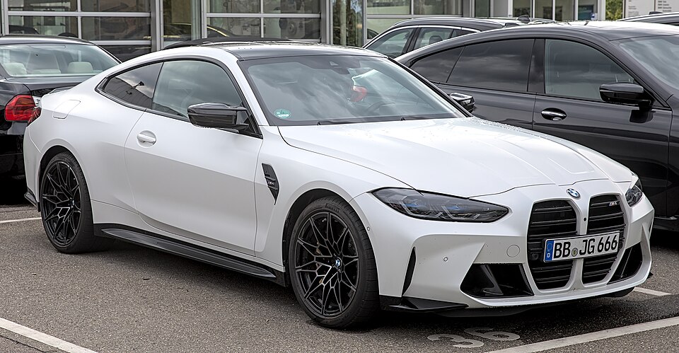Real-world reference photo: BMW M4 (G82), front three-quarter view