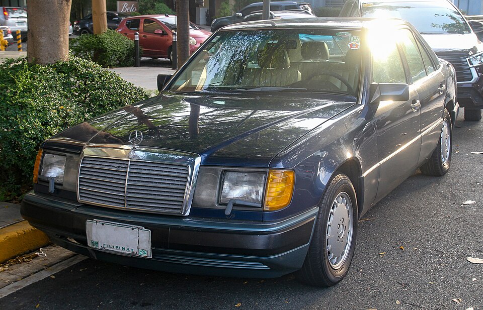 Real-world reference photo: Mercedes-Benz W124 300E in Nautical Blue, front view